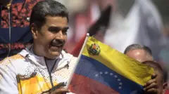 Nicolas Maduro vestindo casaco branco segura bandeira da Venezuelaquanto pode sacar na betnacionalcomício