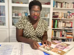 Marie récolte les morceaux de son passé en consultant son dossier d'adoption et des photos de l’époque où elle était encore bébé au Mali