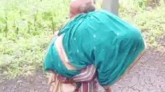 कंधे पर पत्नी का शव ले जाता शख़्स