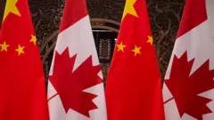 Banderas chinas y canadienses durante una reunión de los presidentes Xi Jinping y Justin Trudeau.