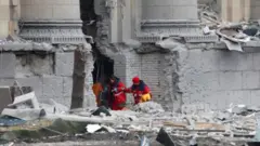 Rescuers dig through rubble after shelling of the state office in Kharkiv