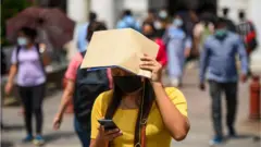 Pedestrians on a hot summer day at Connaught Place, on April 25, 2022 in Delhi
