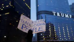 Placard saying "stop killing black and brown people" in front of Trump tower