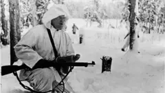 উইন্টার ওয়ার চলার সময় ফিনল্যান্ডের একজন রেডিও রিপোর্টার, যার হাতে মাইক্রোফোন ও অস্ত্র, দুটোই রয়েছে