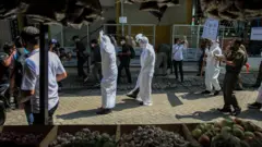 Petugas Satpol PP Kecamatan Larangan mensosialisasikan penggunaan masker dengan menggunakan kostum hantu pocong di Pasar Kreo, Kota Tangerang, Banten, Rabu (16/09)