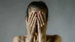 Žena pokriva lice rukama
