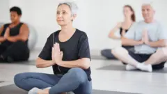 Un grupo de adultos hacen yoga