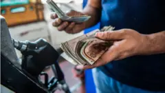 رجل مصري يحاسب عند محطة وقود