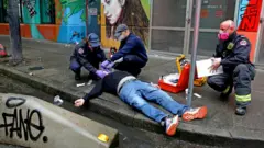 A drug user getting medical help in the street
