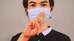 Agne Lay dengan tiga jari di depan wajahnya, simbol perlawanan