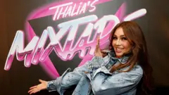 Thalía frente a un cartel de su nuevo disco