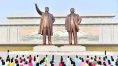 북한 조선중앙통신이 2023년 3월 9일 공개한 이 사진에서 주민들이 김일성 주석과 김정일 국방위원장을 추모하고 있다