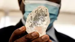 Botswana President Mokgweetsi Masisi holds the diamond in Gaborone, on June 16, 2021