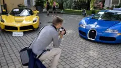 A picture taken on September 28, 2019 at the Bonmont Abbey in Cheserex, western Switzerland shows a 2015 Ferrari LaFerrari (L) and a 2010 Bugatti Veyron EB 16.4 Coupe model car during an auction preview by sales house Bonhams of sport cars belonging to the son of the Equatorial Guinea's President
