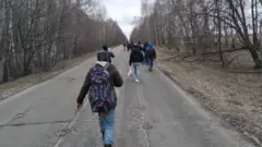 Refugiados afegãos caminham na Ucrânia