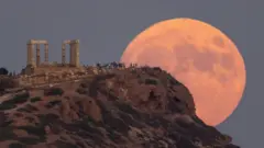 People watch the blue supermoon rising at the Temple of Poseidon, near Athens, Greece. Photo: 30 August 2023