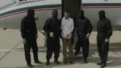 هذه الصورة نشرت في 23 فبراير/شباط 2010 من التلفزيون الإيراني الرسمي تظهر زعيم المتمردين السني عبد الملك ريجي تحت حراسة مسلحة بعد اعتقاله.
