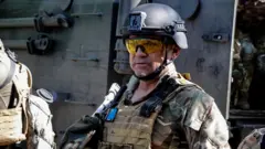 Abarwanyi b'abakorerabushake b'abanyamahanga barwana mu gisirikare cya Ukraine, bahagaze iruhande rw'imodoka, mu gihe igitero cy'Uburusiya muri Ukraine gikomeje i Sievierodonetsk, mu karere ka Luhansk
