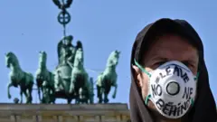 человек в маске в Берлине