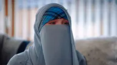 عایشه په سکاټلنډ کې زیږېدلې او لویه شوې ده، خو وايي خلک ګومان کوي هغه د دې ځای نه ده؛ ځکه چې د خپلې اسلامي عقیدې له مخې خپل مخ پټ ساتي.