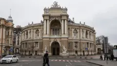 A man walks in front of the Opera Theatre building in Odesa, Ukraine