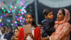 Pakistanda ailələr - çoxu azyaşlı uşaqlarla - Kəraçidəki Müqəddəs Andrew Kilsəsində Milad ərəfəsində keçirilən mərasimə qatılıblar.