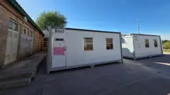 Dois contêineres que funcionam como salas de aula no pátio da escola secundarista CPEM 39