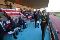 Ebru Eroğlu ve Cumhurbaşkanı Recep Tayyi Erdoğan podyumda. Eroğlu, Erdoğan'ın önünde tören yürüyüşü yapıyor.