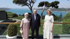 Cumhurbaşkanı Recep Tayyip Erdoğan ve eşi Emine Erdoğan, Kraliçe ile poz verdi. Arkada Boğaz var.