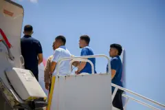 Venezolanos entregados por el gobierno salvadoreño, en la escalerilla del avión que los llevó a Venezuela.