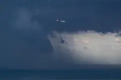 Um avião voa sobre o porto de Barcelona