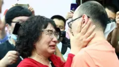 Li Jingzhi llora y abraza a su hijo.
