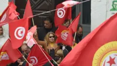 متظاهرون يحملون الاعلام التونسية