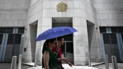Pedestrians walk past the British Consulate-General building in Hong Kong