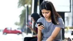 సెల్‌ఫోన్ చూస్తున్న అమ్మాయి