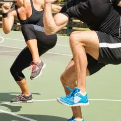 Dois atletas fazendo exercícios de elevação dos joelhos
