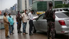 কঠোর বিধি-নিষেধ কার্যকরের সময় গাড়ি চেক করছেন আইনশৃঙ্খলা বাহিনীর সদস্যরা।
