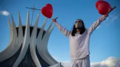 man holding heart balloon