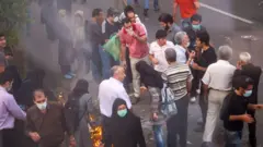 Manifestantes reunidos durante o protesto de 2009, com alguns indivíduos soprando fumaça nos olhos uns dos outros para diminuir o impacto do gás lacrimogêneo.