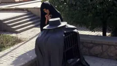 女性がルネ・マグリットの彫刻を熟考しています