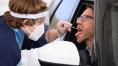 Profissional da saúde coloca swab na boca de um homem