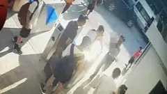 Ảnh chụp màn hình camera quay lúc cháu L. được một người đàn ông đưa vào trong trường sau khi được phát hiện trong ô tô