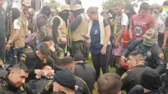 Police officers sit in a circle at a protest in Colombia