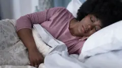Femme qui dort dans son lit