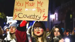 Transparent koji drži demonstrantkinja na protestu protiv strogih zakona o abortusu