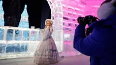 遊客在哈爾濱「冰雪大世界」冰雕前拍照