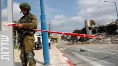 An Israeli soldier closes the road leading to the destroyed police station that was controlled by Hamas militants in the southern city of Sderot, close to the Gaza border, Israel, 08 October 2023