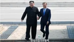 2018년 4월 27일 문재인 대통령과 김정은 북한 국무위원장이 남북정상회담이 열린 판문점에서 만나 손을 잡고 함께 군사분계선을 넘는 모습