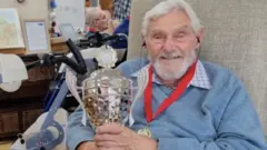 Kenneth Judd with his medal and trophy