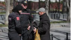 ضباط إنفاذ القانون في مولدوفا يفحصون متعلقات رجل خلال احتجاج مناهض للحكومة في كيشيناو، مولدوفا، 12 مارس/آذار 2023